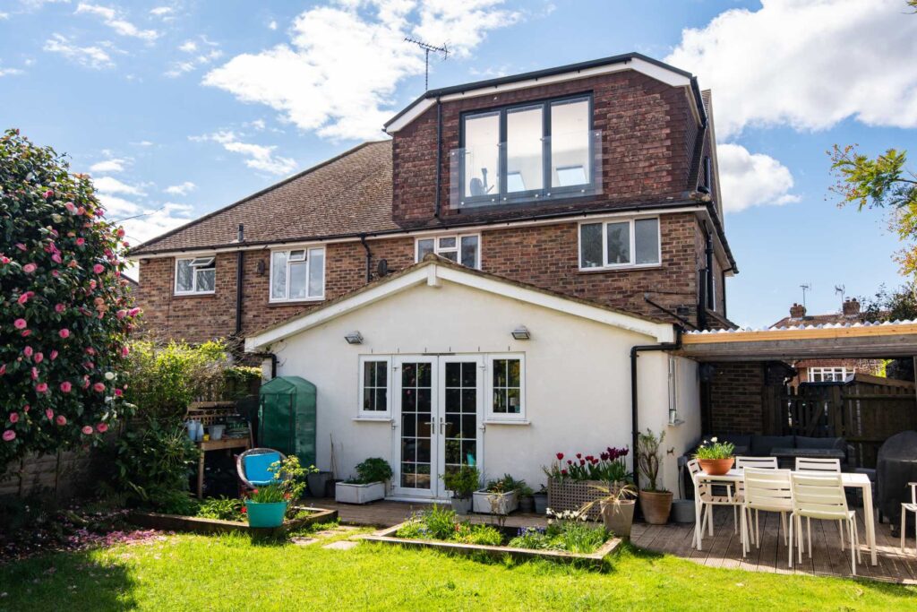 An aesthetically pleasing loft conversion project featuring a dormer with a glass-fronted Juliet balcony, creating a light and spacious interior in a UK home. A perfect example of a home improvement project.