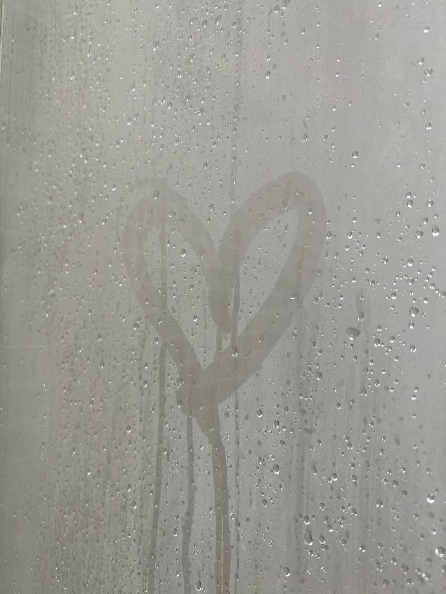 A heart drawn in the condensation on a window. This image represents the importance of managing condensation in buildings to maintain a healthy indoor environment. Proper ventilation and moisture management can prevent the buildup of condensation and promote comfort and wellbeing for building occupants.