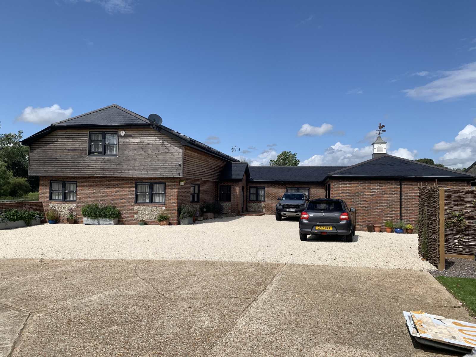 An energy-efficient Passive House featuring a timber frame, cantilevered first floor, and Sussex hip roof, designed by Shear Architectural Design.