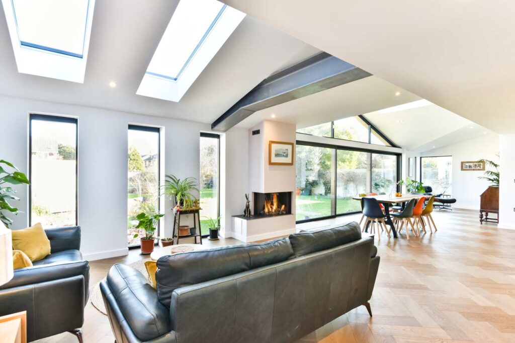 An elegant living room bathed in natural light from skylights on the ceiling, showcasing the transformative effect of these sustainable architectural design features.
