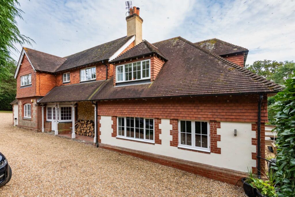 Exterior view of a newly renovated house with modern architectural design and lush garden.